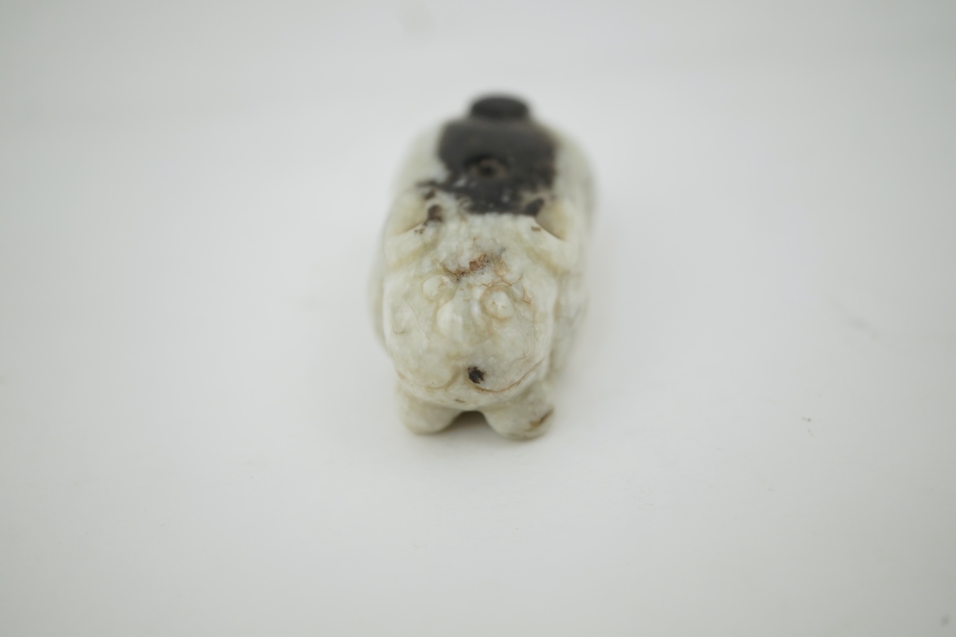A Chinese white and black jade figure of a recumbent tiger, Song dynasty